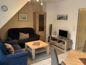 ein Wohnzimmer mit einem Sofa und einem TV in der Unterkunft Nordseeperle in Wangerland