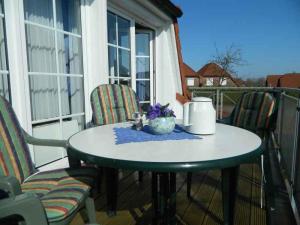 einen kleinen Tisch auf einer Veranda mit Stühlen und Aperitif in der Unterkunft Nordseeperle in Wangerland