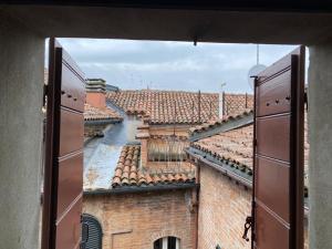una ventana con vistas a un edificio con techos en Le Case Cavallini Sgarbi di Rina Cavallini, en Ferrara