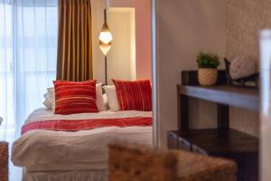 - une chambre avec un lit doté d'oreillers rouges et d'un miroir dans l'établissement LANDMARK NAMBA TSUTENKAKU, à Osaka