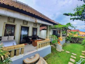 a villa with a bedroom and a garden at Solaluna Beach Homestay in Amed