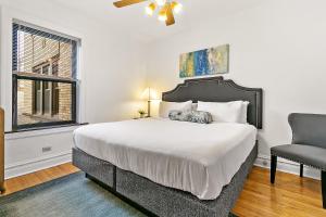a bedroom with a large bed and a chair at Your 1BR Homey Haven in Vibrant Chicago - Larchmont 1A-3A in Chicago