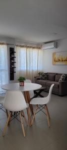 ein Wohnzimmer mit einem Tisch und 2 weißen Stühlen in der Unterkunft Beira mar Meireles a um passo do mar in Fortaleza