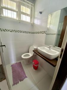 uma casa de banho com um lavatório, um WC e um espelho. em Ampla casa com piscina a 200 metros da praia do Lazaro e Sununga em Ubatuba