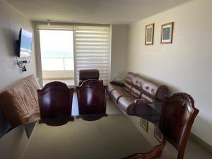 a living room with a couch and a glass table at Condominio Laguna del Mar in La Serena