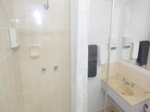 a bathroom with a shower and a sink at Banjo Paterson Motor Inn in Townsville