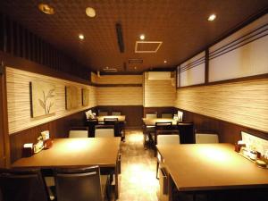 
a room with a table, chairs, and a large window at Hotel Route-Inn Kitamatsudo Ekimae in Matsudo
