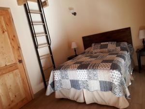 1 dormitorio con cama y escalera de madera en Estancia del Monje, en Cobán