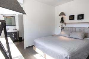 biała sypialnia z łóżkiem i lustrem w obiekcie Grand Case Bleu Marine Sea Side w mieście Grand Case