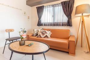 a living room with a couch and a table at Bijou Suites Bloom in Osaka