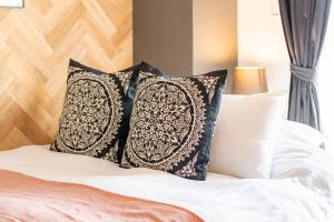 a bed with black and white pillows on it at Bijou Suites Bloom in Osaka +31 photos
