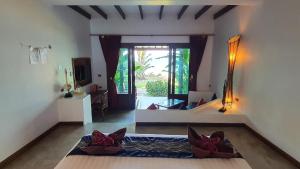 um quarto com uma cama e uma grande janela em Andalay Boutique Resort em Ko Lanta