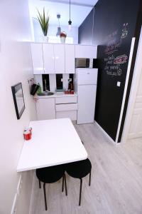 a kitchen with a white table and a black and white refrigerator at The Hostel in Zadar