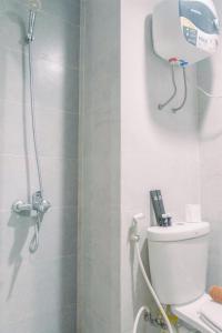 a bathroom with a shower with a toilet in it at Classic Studio Room Apartment at Taman Melati Surabaya By Travelio in Surabaya