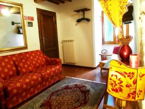 
a living room filled with furniture and a red couch at Guest House il Borgo di Sempronio in Semproniano
