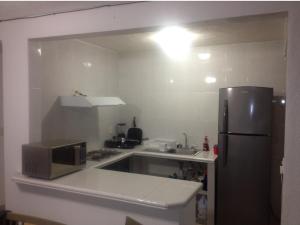 a kitchen with a microwave and a refrigerator at Deep Ocean Acapulco in Acapulco