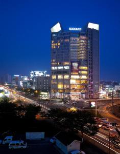 a lit up building in a city at night at Ecograd Hotel in Suncheon