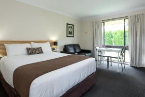 利斯戈Zig Zag Motel & Apartments的一间酒店房间，配有一张大床和一张书桌