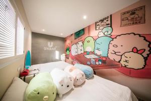 a room with a bed with stuffed animals on it at Urban in Kaohsiung