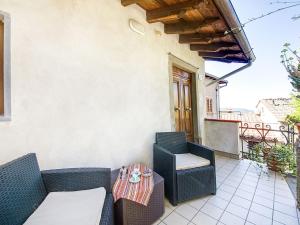 eine Terrasse mit 2 Korbstühlen und einem Tisch in der Unterkunft Belvilla by OYO Gelsomino Piccolo in Cocciglia