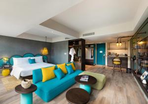 a bedroom with a bed and a blue couch at MAMAKA Bali in Kuta