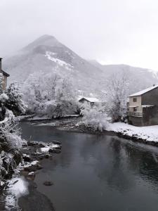 un río con nieve en el suelo junto a una montaña en PAS à PAS CHAMBRE D'HOTES, en Sarrancolin