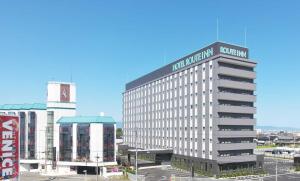 un edificio con un cartel en la parte superior en Hotel Route Inn Kusatsu Ritto -Ritto Inter Kokudo 1 gou- en Ritto