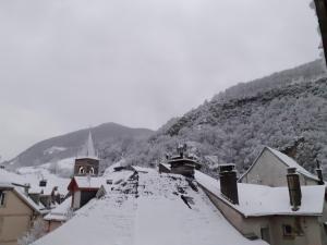 une ville recouverte de neige avec une montagne en arrière-plan dans l'établissement PAS à PAS CHAMBRE D'HOTES, à Sarrancolin
