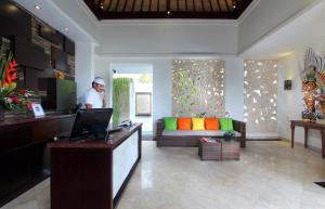 a man standing in a living room with a laptop at RC Villas and Spa Bali in Seminyak