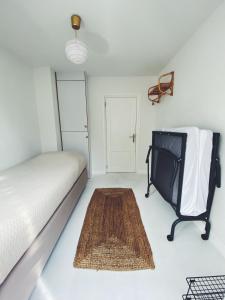 1 dormitorio con 1 cama, 1 silla y 1 alfombra en ECHT-Bergen, en Bergen