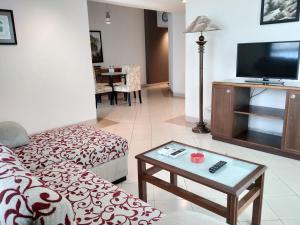 a living room with a couch and a tv at Apartemen Puncak Marina in Surabaya