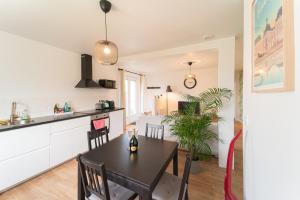 a kitchen and dining room with a table and chairs at La CAPEYRONNAISE - MAISON COSY - JARDIN in Mérignac