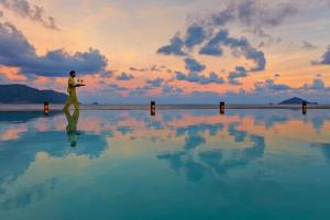 a man walking on top of a body of water at Six Senses Con Dao - Turtle Island Paradise in Con Dao