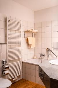 a white bathroom with a sink and a tub at Hotel Blauer Engel in Aue