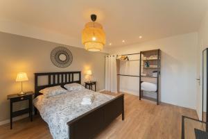 a bedroom with a bed and a chandelier at La CAPEYRONNAISE - MAISON COSY - JARDIN in Mérignac