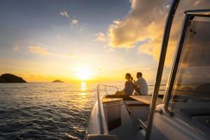 a couple sitting on a boat watching the sunset at Six Senses Con Dao - Turtle Island Paradise in Con Dao