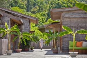 a woman walking through a courtyard with plants at Six Senses Con Dao - Turtle Island Paradise in Con Dao