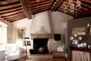 a living room with a fireplace and a chandelier at Guest House il Borgo di Sempronio in Semproniano