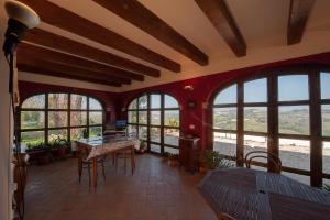 Habitación con mesa, sillas y ventanas. en B&B Punto Magico, en Offagna