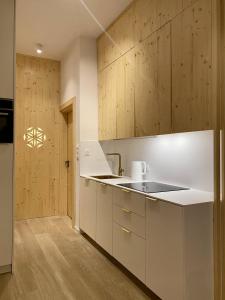 een keuken met witte werkbladen en houten kasten bij Apartament Skiturowy Jagiellonska Residence in Zakopane