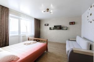 ケメロヴォにあるAvant Apartment Svobody 19のベッドルーム1室(ベッド1台、ソファ、窓付)