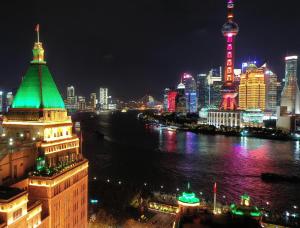 上海的住宿－上海和平饭店，城市天际线,夜晚有河流和建筑