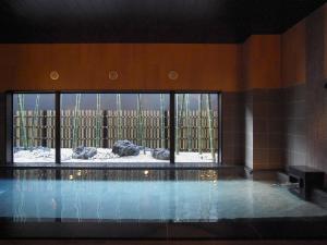 a swimming pool in a building with a large window at Hotel Route-Inn Nihonmatsu in Nihommatsu