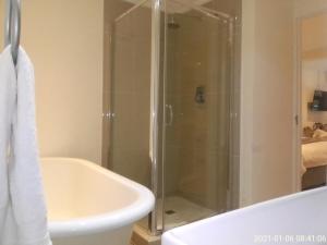 y baño con ducha, bañera y lavamanos. en Victoria & Alfred Boutique Hotel en Puerto Elizabeth