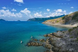 a person in the water near a rocky beach at Six Senses Con Dao - Turtle Island Paradise in Con Dao