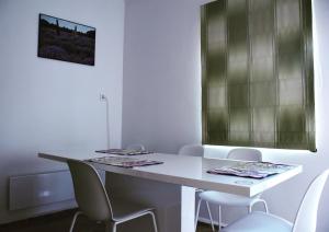 ein weißes Zimmer mit einem weißen Tisch und Stühlen in der Unterkunft Pellegrini Apartman in Balatonakali
