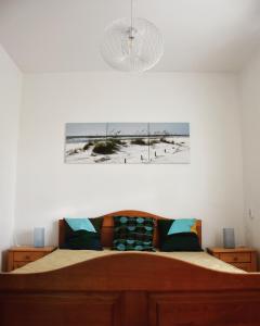 Pellegrini Apartman في بالاتوناكالي: غرفة نوم بسرير وصورة للشاطئ