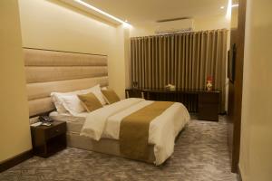 a hotel room with a bed and a desk at Richmond Hotel Sylhet in Sylhet