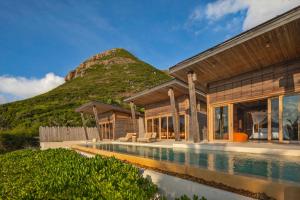una casa con piscina frente a una montaña en Six Senses Con Dao - Turtle Island Paradise, en Con Dao