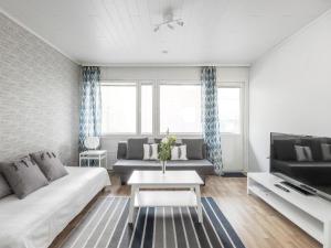 a living room with a couch and a table at Kotimaailma Apartments Joensuu in Joensuu